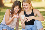 Happy, park and phone with a couple of friends online together for funny comic social media post. Women outdoor on grass with smartphone for communication, 5g connection and typing search on internet