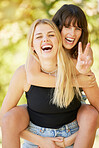 Woman, friends and smile with peace sign for piggyback, friendship or summer holiday break together in nature. Happy women enjoying back ride, laughing or smiling for fun travel, trip or outdoor walk