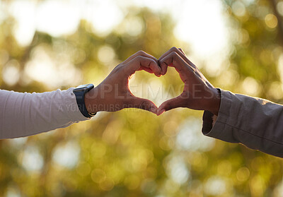 Buy stock photo Hands, heart and love with a couple outdoor on a date, bonding during summer for romance. Nature, emoji or hand sign with a man and woman outside in a park or natural environment on a sunny day