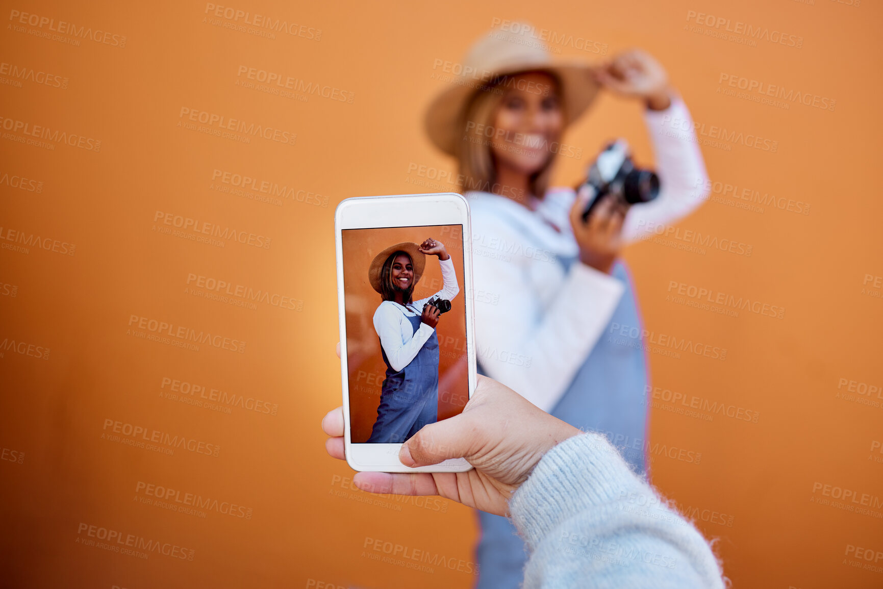 Buy stock photo Friends taking picture on a phone of woman isolated on wall background on social media or digital memory. Hand holding smartphone screen for happy profile of gen z, influencer person in summer mockup