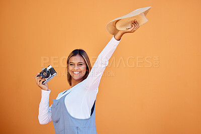 Buy stock photo Happy woman, photographer and retro camera on an orange wall for advertising vacation, holiday or creativity. Person with a smile and hat for summer travel photography, memory and color background