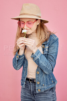 Buy stock photo Young girl, smell flower and smile for modern gen z or millennial fashion, freedom and calm peace in pink background. Happy female, flowers scent and happiness with trendy or edgy clothes in studio