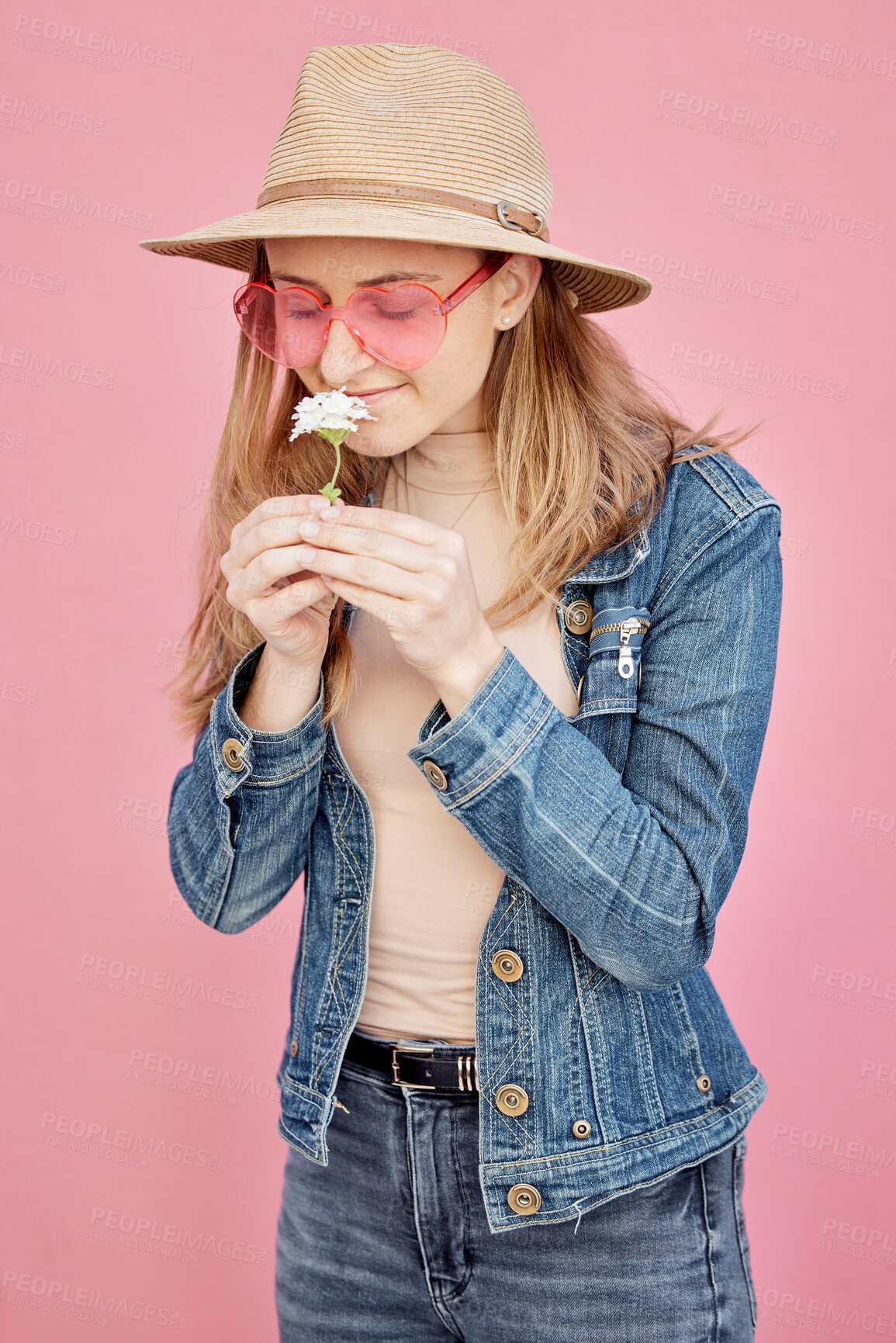 Buy stock photo Young girl, smell flower and smile for modern gen z or millennial fashion, freedom and calm peace in pink background. Happy female, flowers scent and happiness with trendy or edgy clothes in studio