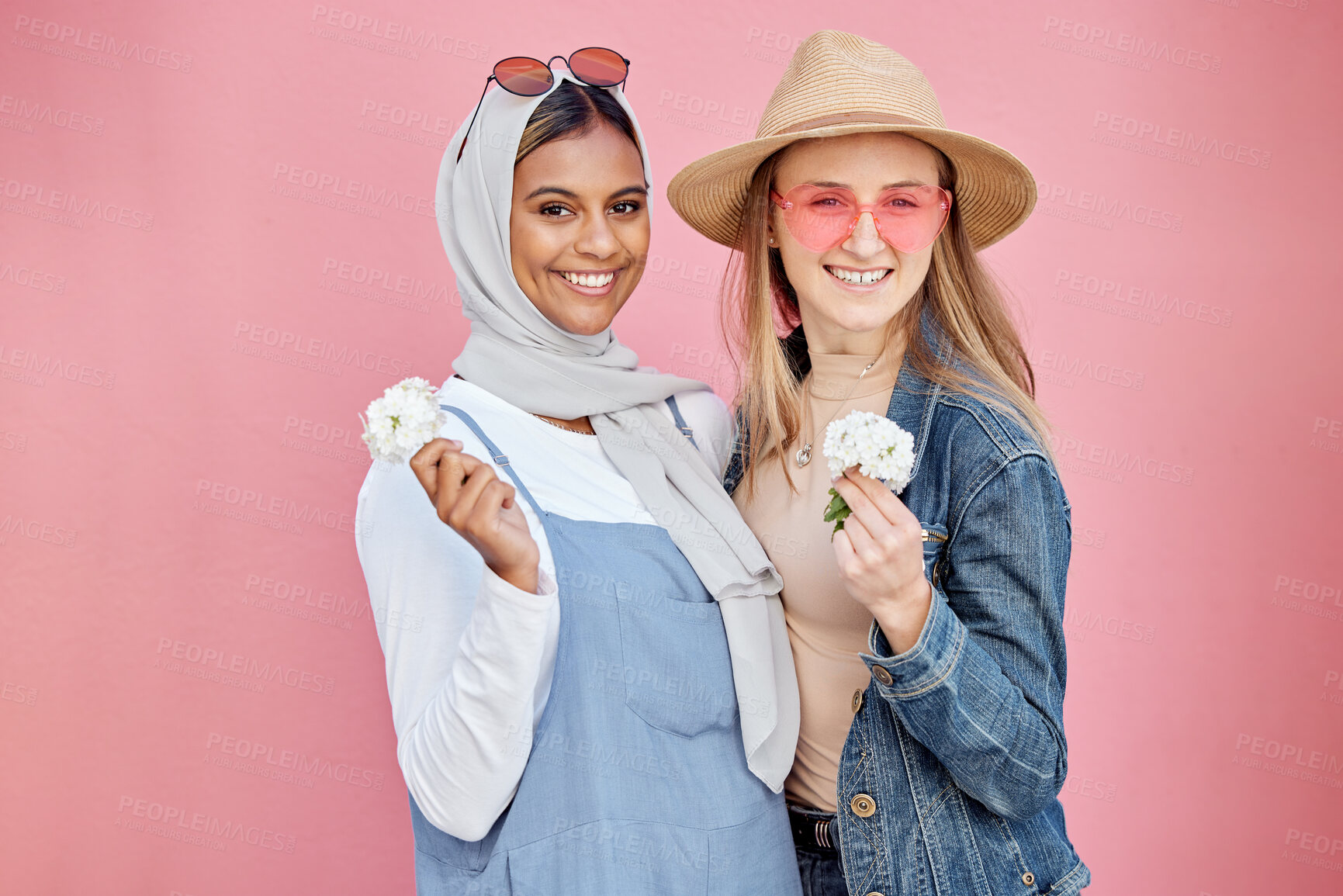 Buy stock photo Friends, diversity and fashion women portrait with spring flowers on a pink background with a happy smile. Muslim woman and girl together for hug, love and support for lgbt freedom, respect and pride