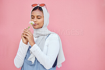 Buy stock photo Young Islamic girl, smell flower and modern gen z or millennial fashion, zen freedom and calm peace in pink background. Muslim female, flowers scent and hijab with trendy or edgy clothes in studio