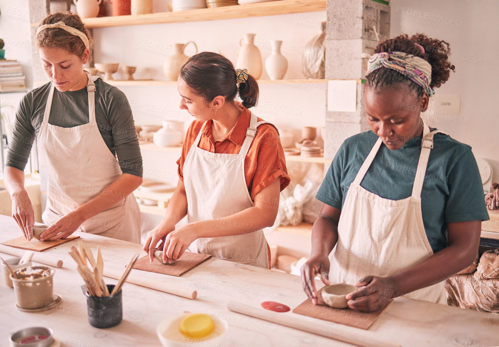 Buy stock photo Pottery sculpting and people row at workshop together for creative process, production and productivity. Focus, concentration and talent of interracial team of women in artistic workspace.