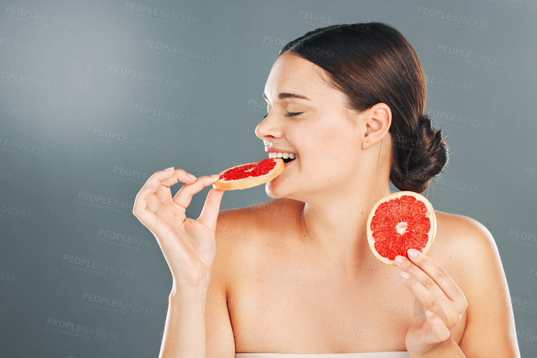 Buy stock photo Grapefruit, skincare and woman eating on studio background for wellness benefits. Beauty model diet with citrus fruits, natural detox and nutrition of healthy food, happy face and smile for vitamin c