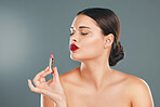 Lipstick, woman and makeup in studio for skincare, cosmetics and aesthetics. Young model face, red colorful lips and beauty product for luxury fashion, salon and cruelty free facial balm application 