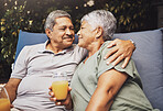 Senior couple, hug and juice on a garden patio sofa with love and care for marriage and retirement. Conversation, morning talking and relax discussion of elderly man and woman outdoor with happiness