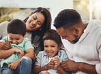 Love, happy and parents tickling their children in the outdoor backyard of their family home. Happiness, smile and young couple spending quality time, bonding and fun with their kids in house garden.