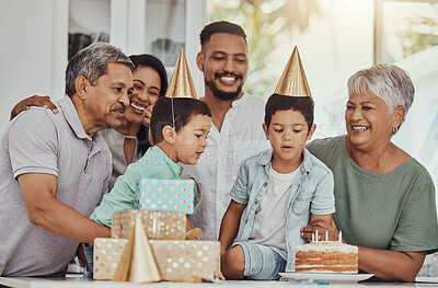 Buy stock photo Birthday, celebration and twins blowing the candles on a cake at their party with family. Happy, excited and children with their parents and grandparents at event in a kitchen of a home to celebrate.