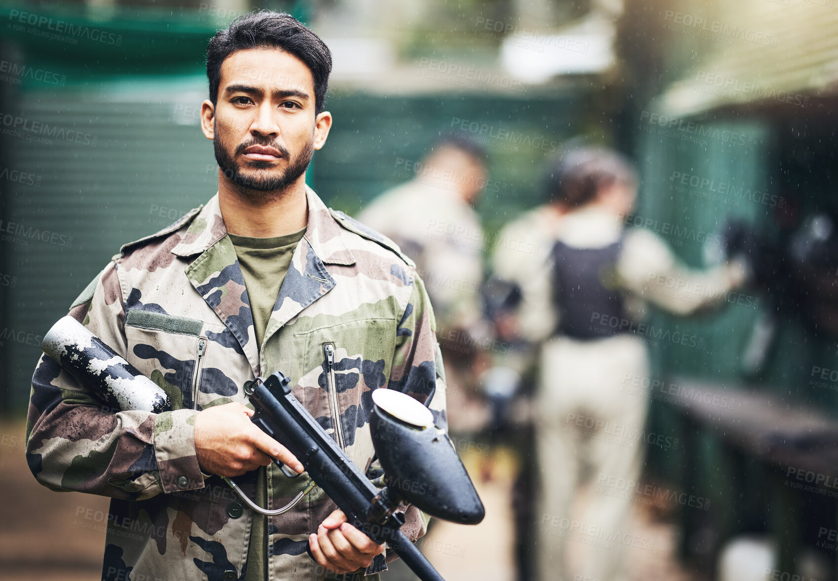 Buy stock photo Portrait, paintball and camouflage with a sports man holding a gun for a game or competition. Fitness, exercise and serious with a male athlete carrying a weapon or marker for military training