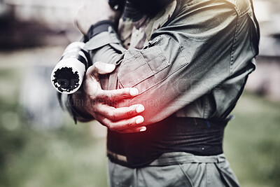 Buy stock photo Paintball, pain or man with an elbow injury after playing a shooting game on a fun battlefield on holiday. Red glow, fitness or hands of player in an arm accident in an outdoor military competition
