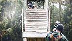 Paintball, aim and man shooting while playing a action match on an outdoor battlefield competition. Focus, gear and male military soldier player aiming to shoot with a weapon at a game at an arena.