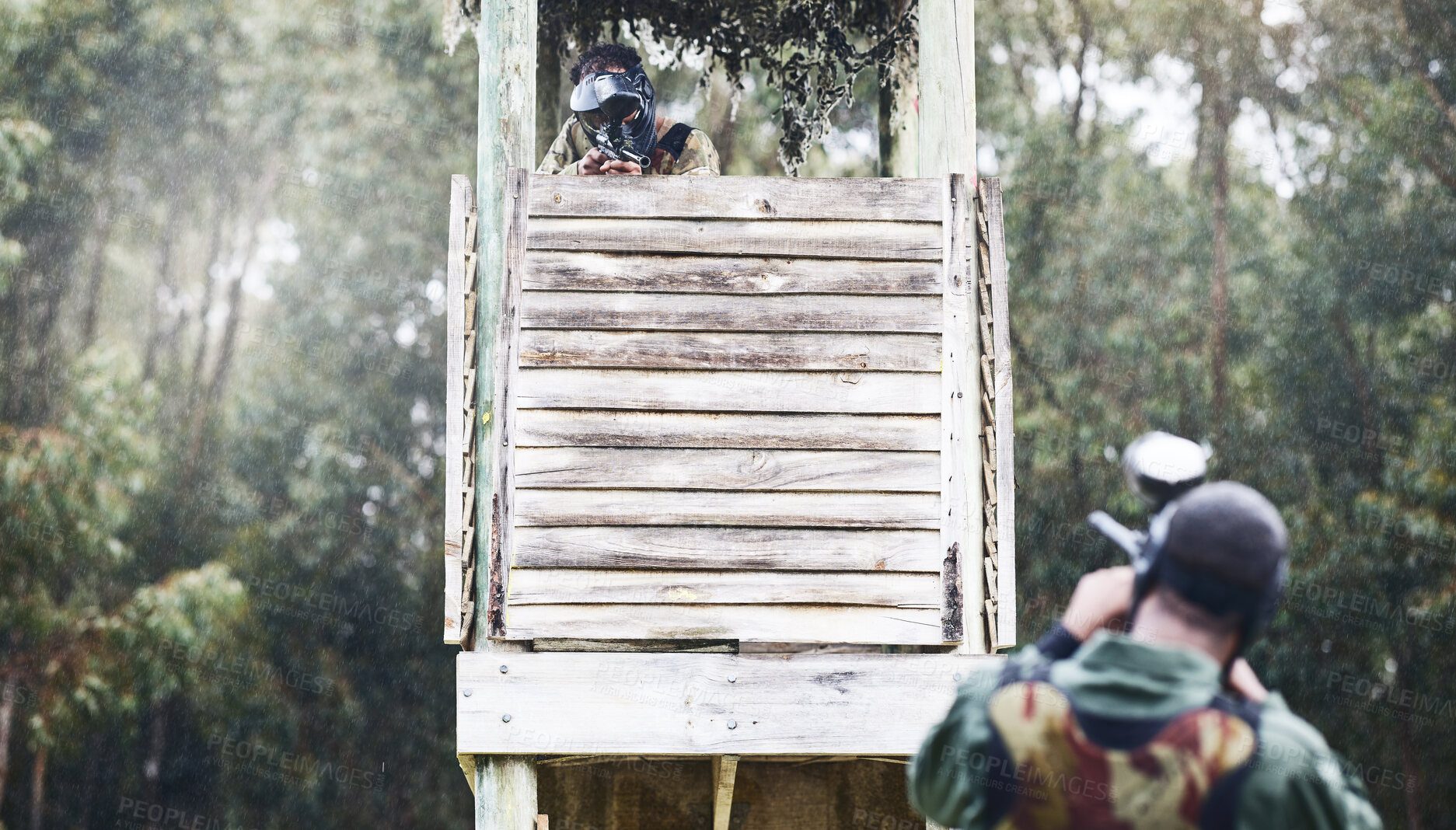 Buy stock photo Paintball, aim and man shooting while playing a action match on an outdoor battlefield competition. Focus, gear and male military soldier player aiming to shoot with a weapon at a game at an arena.