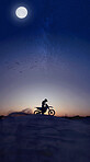 Motorcycle, sport and silhouette riding against night, sky and background in nature, extreme sports and adrenaline. Biking, motorbike and person driving on dirt road, dark and shadow, stunt and free