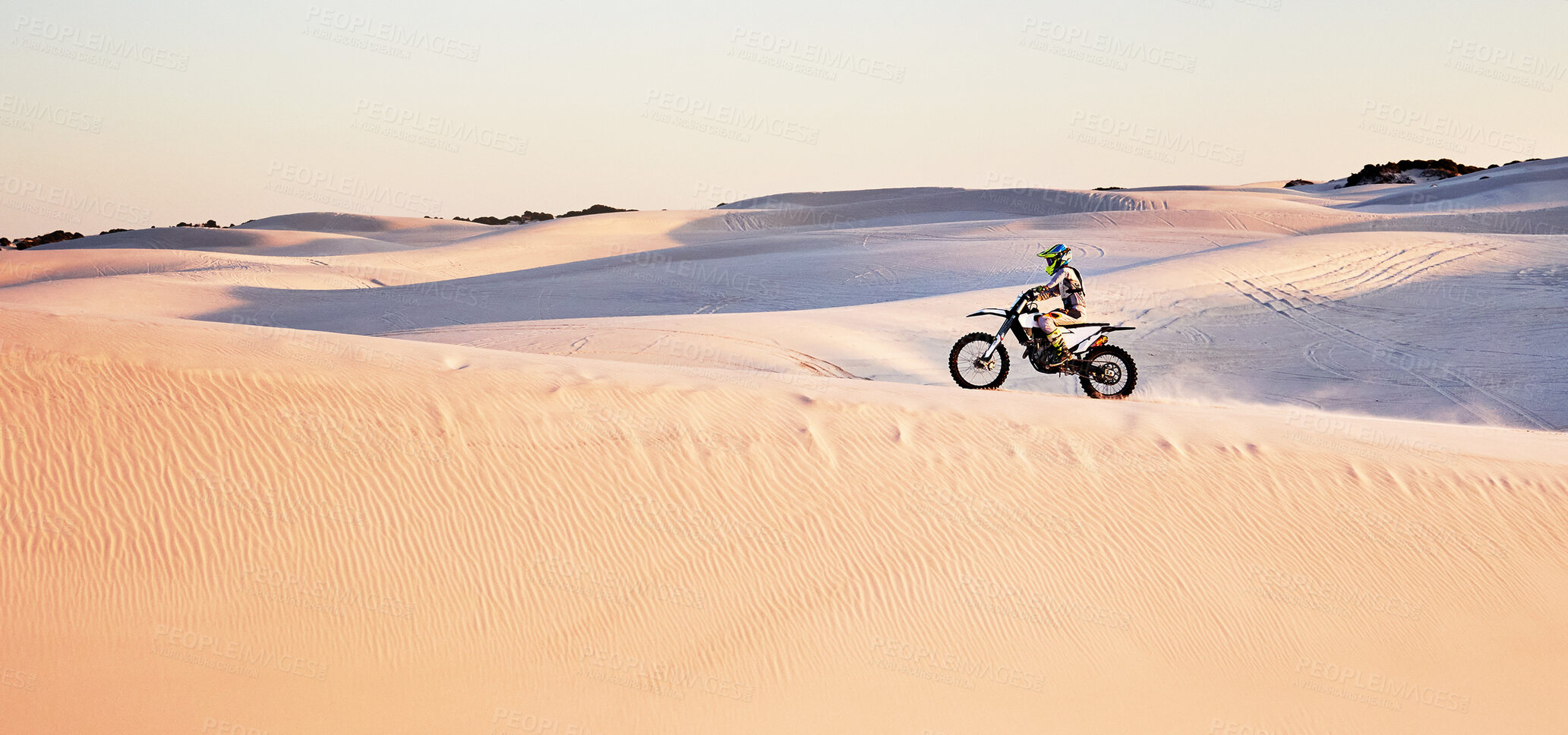 Buy stock photo Desert, nature and athlete riding a motorcycle for exercise, fitness or skill training in nature. Extreme sports, action and male athlete on a bike for an outdoor workout in the sand dunes in Dubai.