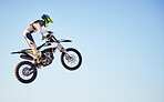 Motorcycle, jump and person on blue sky mockup for training, competition or challenge with safety gear. Professional cycling, motorbike and adventure with speed, sports and danger in mock up space
