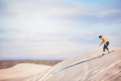 Buy stock photo Sandboard, desert and mockup with a sports man outdoor on the sand dunes for recreation, fun or adventure. Sky, nature and mock up with a male athlete or sandboarding moving downhill at speed 