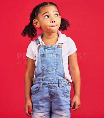 Buy stock photo Thinking, girl and red studio background of an isolated young child with an idea and casual fashion. Relax, youth ideas and calm child feeling curious alone with denim dungarees of cute kid 
