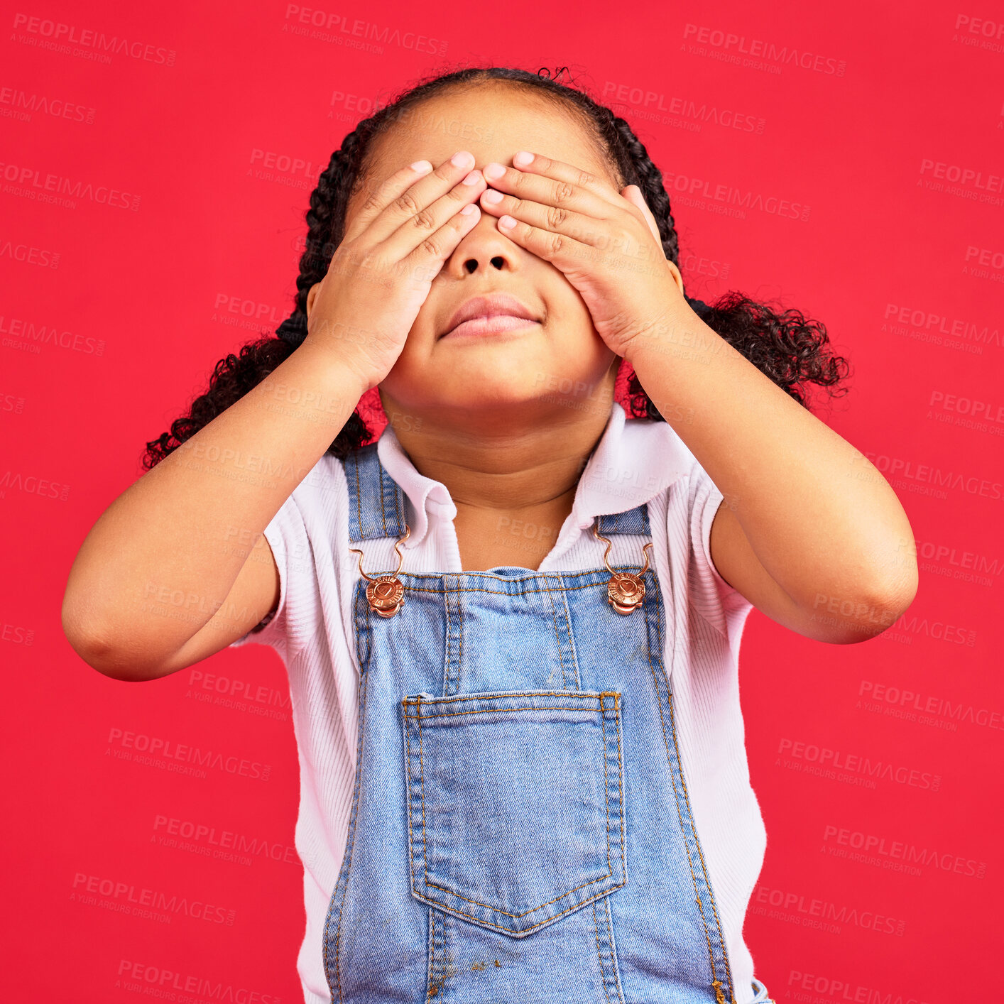 Buy stock photo Little girl, hands and eyes cover on isolated red background for shy, mistake expression and peekaboo games. Child, kid and youth in hide and seek activity, surprise gesture or blind emoji on studio