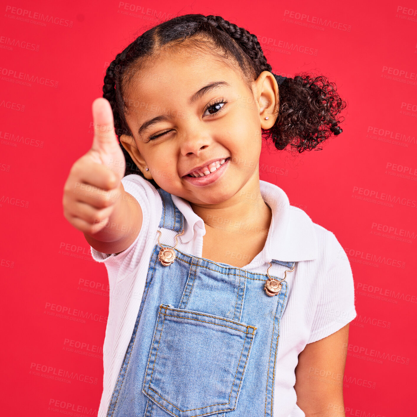 Buy stock photo Thumbs up, portrait and girl child in studio, red background or isolated hand sign. Happy kids, thumb gesture and wink face of like emoji, support and vote of trust, thanks or yes agreement of review
