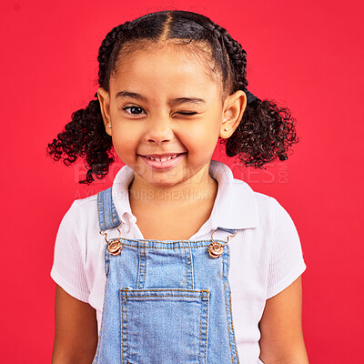 Buy stock photo Portrait, wink and a black child on a red background in studio having fun or feeling carefree. Kids, fashion and smile with a happy female child winking inside on a color wall while looking funny