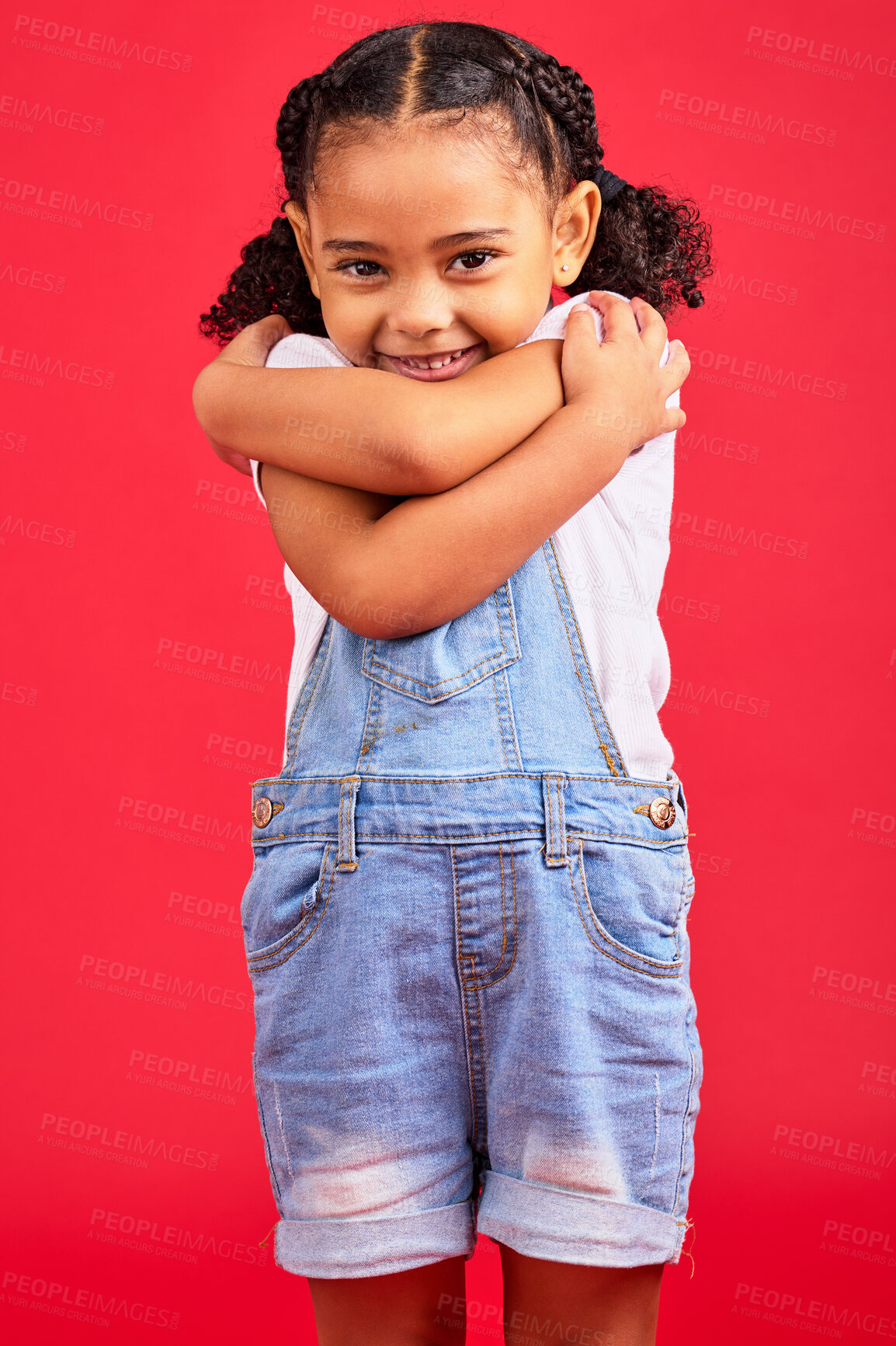 Buy stock photo Portrait, hug and girl in studio, happy and smile against red background with mockup. Face, love and caring toddler standing against space, embrace and positive, smiling and self love while isolated