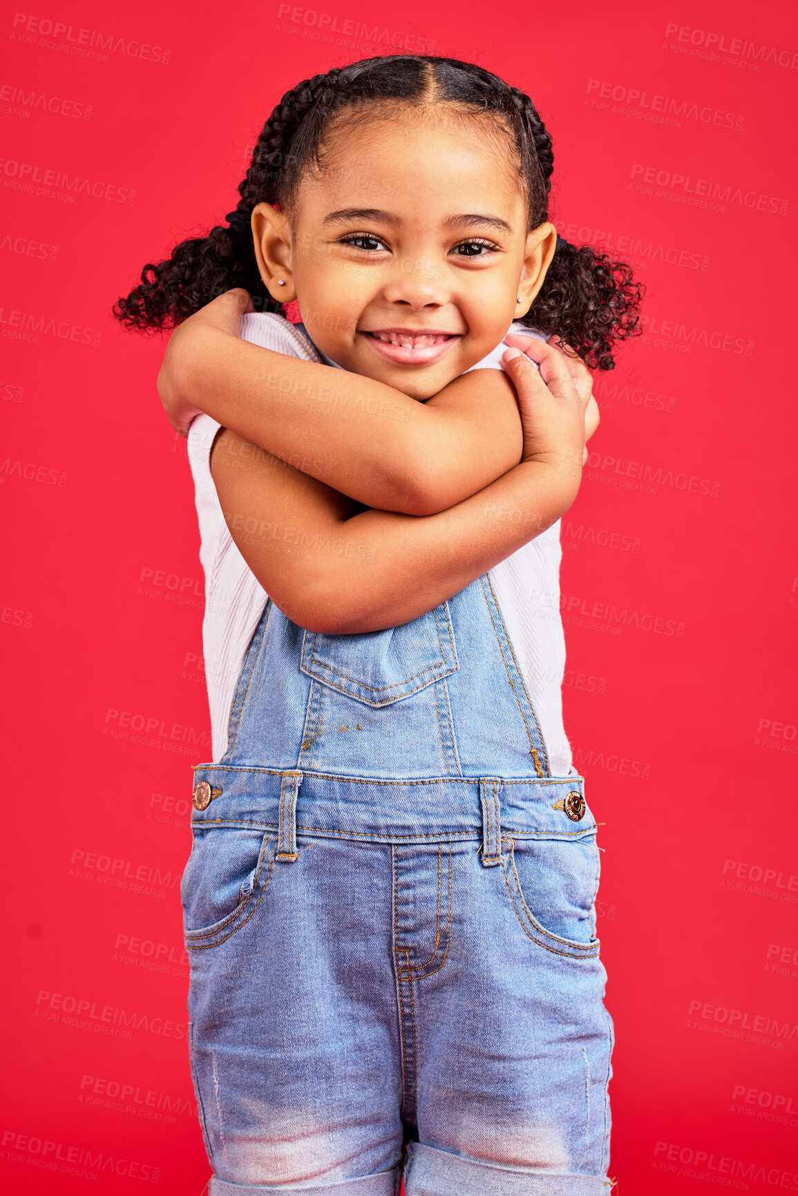 Buy stock photo Portrait, hug and girl in studio for self love, sweet and loving gesture against red background with mockup. Face, child and happy, smile and toddler embracing, care and confident while isolated