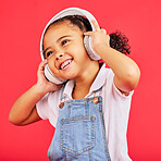 Dancing, kid and headphones for music, fun radio and girls podcast on isolated red background and studio. Smile, happy and energy child listening to dance audio, sound and streaming media on backdrop