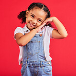 Little girl, cute and shy expression on isolated red background in fashion, trendy or cool clothes and curly hair. Smile, happy child and kid and innocent face, playful or blushing gesture on studio