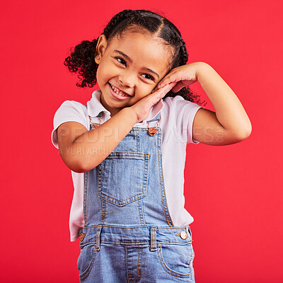 Buy stock photo Little girl, cute and shy expression on isolated red background in fashion, trendy or cool clothes and curly hair. Smile, happy child and kid and innocent face, playful or blushing gesture on studio