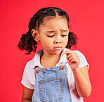 Child, sad and finger injury with plaster on isolated red background for cut, sore and insect bite. Upset, unhappy and hurt little girl with bandage for medical help, healthcare wellness or first aid