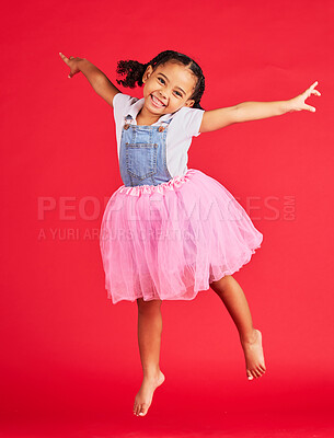 Buy stock photo Portrait, girl and jumping in tutu skirt on red background, studio and fun fashion. Happy kid, ballet clothes and energy for performance, dance and smile with happiness, ballerina dress and princess