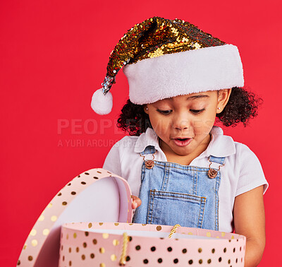 Buy stock photo Christmas, gift and girl child surprise, wow and curious in studio, happy and shock against red background. Box, present and excited toddler express omg, cheer and happiness for festive celebration