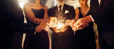 Buy stock photo Fire, sparklers and people at a luxury party, event or celebration for new year with formal outfit. Celebrate, matches and group of friends in classy clothes at a black tie gala, banquet or dinner.