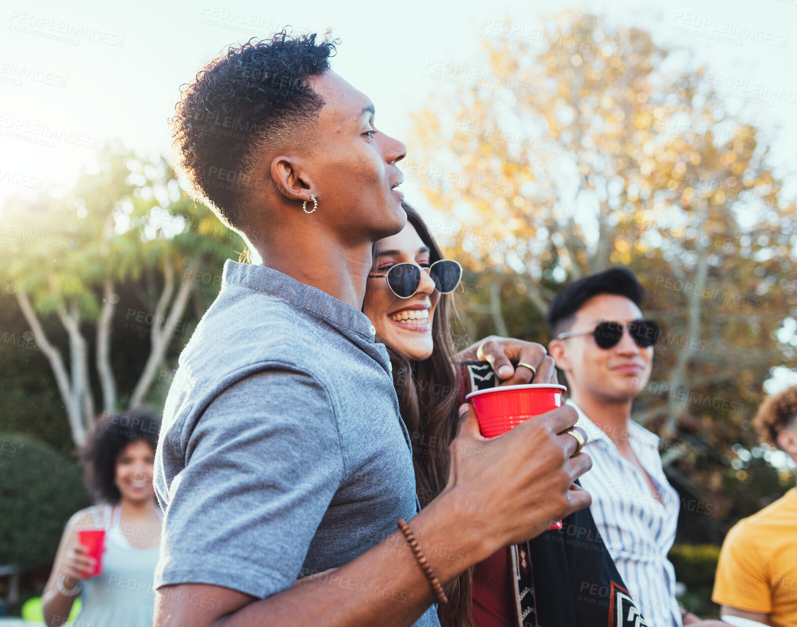 Buy stock photo Drinks, party and a couple of friends outdoor to celebrate at  festival, concert or summer social event. Diversity young men and women crowd while happy, hug and drinking alcohol while listening