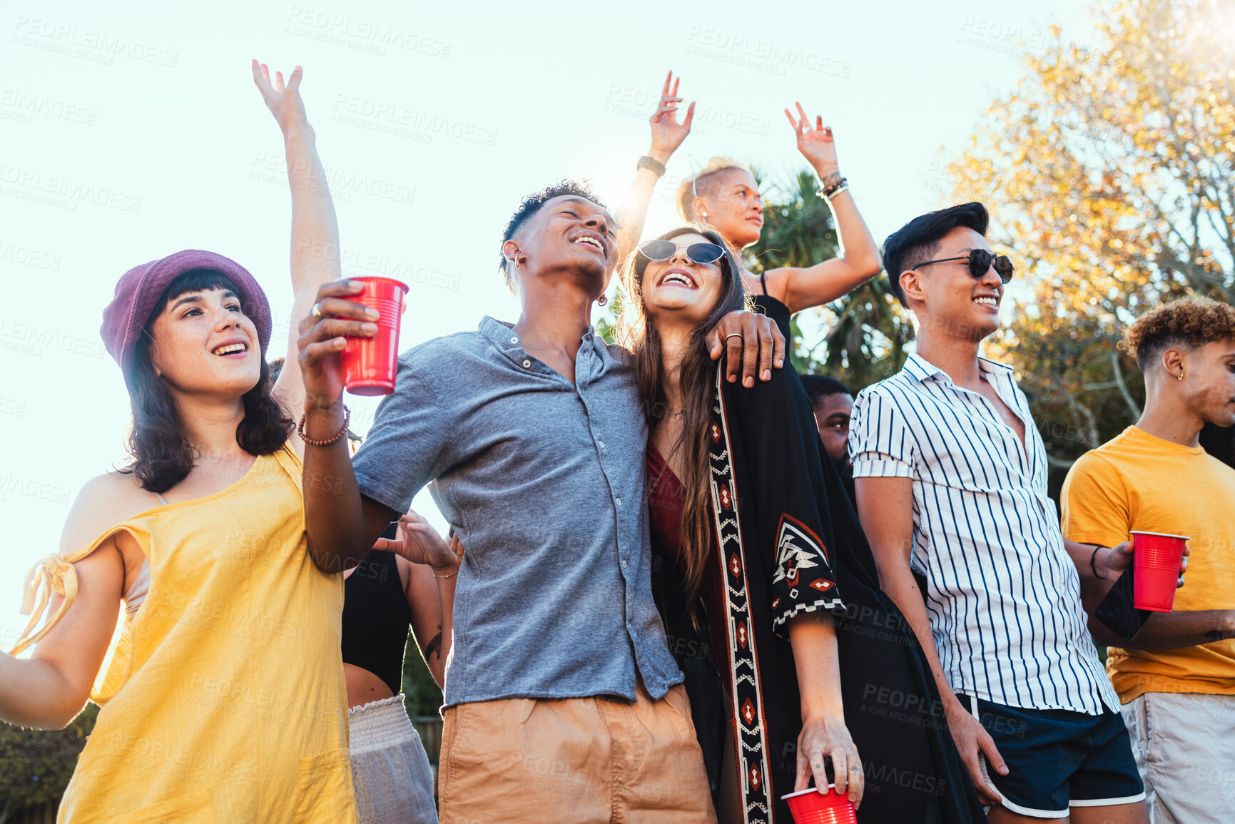 Buy stock photo Drinks, party and a couple of friends dancing outdoor to celebrate at festival, concert or social event. Diversity young men and women people together while happy, singing and drinking alcohol