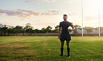 Rugby player, sports and standing on field with ball ready for game, match or practice outdoors. Sporty man athlete or professional waiting for rugby competition, training or play time on green grass