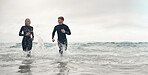 Running, surfing and mockup with a sports couple in the ocean or sea for leisure or recreation. Beach, fitness and mock up with a man and woman training together in the water during summer