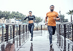 Personal trainer, rain and athletes running as exercise on a city bridge training, fitness or workout outdoors in town. People or fit friends sprint fast for wellness, cardio and health lifestyle