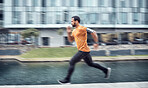 Blurred, fitness and man running as exercise in the city training, workout and workout outdoors in a town. Athlete, runner and fit male sprint fast for wellness, cardio and health lifestyle