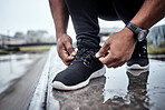 Fitness, shoes and running with a sports man tying his laces for an outdoor cardio or endurance workout. Exercise, footwear and training with a male athlete or runner fastening his shoelaces outside