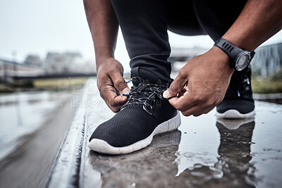 Buy stock photo Fitness, shoes and running with a sports man tying his laces for an outdoor cardio or endurance workout. Exercise, footwear and training with a male athlete or runner fastening his shoelaces outside