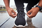 Exercise, shoes and running with a sports man tying his laces for an outdoor cardio or endurance workout. Fitness, footwear and training with a male athlete or runner fastening his shoelaces outside