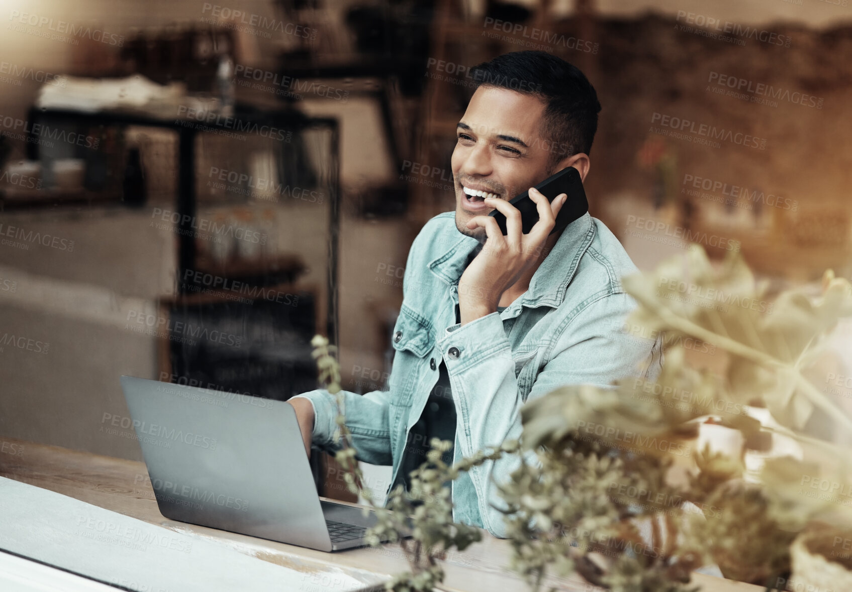 Buy stock photo Creative man, phone call and laptop laughing at cafe for communication, social network or funny conversation. Happy male freelancer laugh for joke or startup on smartphone at coffee shop restaurant