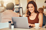 Woman, typing and laptop in cafe of remote worker, planning freelance research or restaurant. Happy female, coffee shop and computer email technology on internet, blogging or social networking online