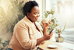 Coffee shop, phone and communication with a black woman customer drinking while typing a text message by a window. Internet cafe, mobile or social media with a female enjoying a drink in a restaurant