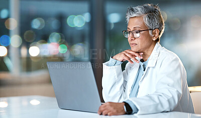 Buy stock photo Laptop, doctor and senior woman in hospital working late or overtime on email, telehealth or research. Bokeh, thinking and female medical physician reading healthcare information at night on computer