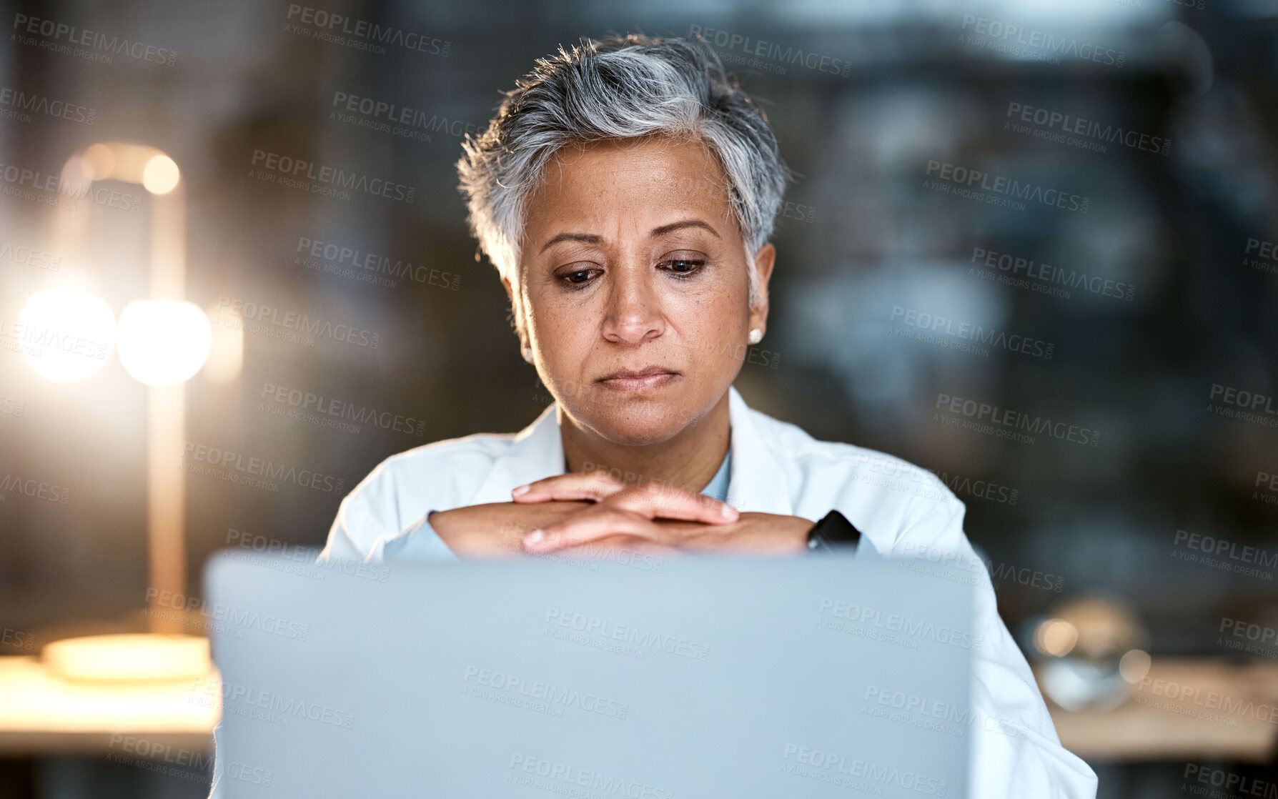 Buy stock photo Senior woman, doctor and laptop at night thinking for healthcare solution, idea or strategy at hospital. Elderly female medical expert working late on computer and contemplating decision or choice